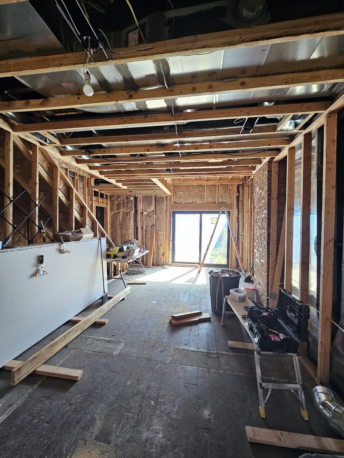 Full interior gut renovation with exposed framing, insulation, and new drywall staged for installation